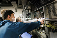 Students work out class assignments at the power panels in the PKI lighting lab. College of Engineer