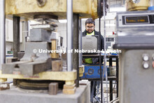 Soumitra Das compresses a sample in George Morcous’ lab. Smart phones are used to photograph the s