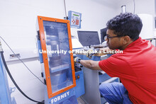 Dulitha Frederick compresses a sample in George Morcous’ lab.  Smart phones are used to photograph