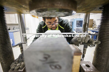 Soumitra Das sets up measuring equipment on a sample in George Morcous’ lab. Smart phones are used