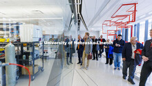 Board of Regents look through the glass walls of one of the labs in the newly built Engineering Rese