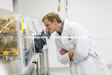 UNMC Student Regent Taylor Kratochvil looks over the mouse habitats in the Nebraska Gnotobiotic Mous