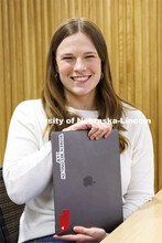 A student shows a sticker on her laptop "Women Belong in Law". College of Law photo shoot. April 20,