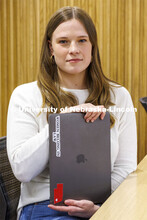 A student shows a sticker on her laptop "Women Belong in Law". College of Law photo shoot. April 20,