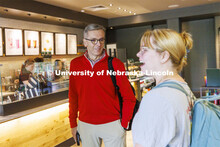 UNL Chancellor Ronnie Green chats with graduating senior Elinor Stanley as they wait for their coffe