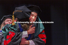 Nicholas Harp hugs Maital Neta after receiving his doctoral degree. Graduate commencement in Pinnacl