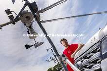 Dallas McKinney poses with the MesoNet vehicles as the team prepares to chase summer storms. After t