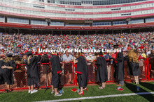 Graduates, friends and family talk at the end of the field before commencement. UNL undergraduate co