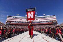 The Nebraska gonfalon leads the procession. UNL undergraduate commencement in Memorial Stadium. May 