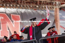 CoJMC graduate Allan Fisher shows off his diploma to family and friends. UNL undergraduate commencem