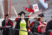 Kira Taylore waves to family and friends after receiving her diploma. UNL undergraduate commencement