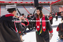 Katelyn Hill high fives a friend after she received her diploma. UNL undergraduate commencement in M
