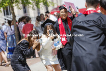 New grads pose for photos with their families. UNL undergraduate commencement in Memorial Stadium. M