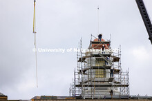 Walkway pieces are relayed into place as scaffolding work begins to surround the Love Library cupola