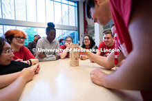 Attendees take turns removing blocks during a game of Jenga at the Nebraska College Preparatory Acad