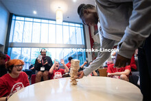 Attendees take turns removing blocks during a game of Jenga at the Nebraska College Preparatory Acad