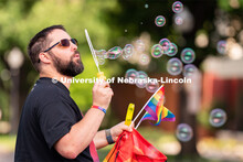 A parade-goer blows bubbles as they walk around the Lincoln Capitol Building during the Star City Pr