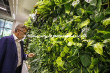 Chancellor Ronnie Green takes a closer look of a living wall in the new wellness area of the law lib