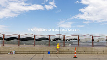 Reni Buehler rolls the wave-patterned artwork on the overpass. Building Systems Maintenance paints t