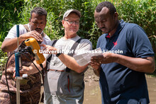 Research Engineer Alan Boldt (center) assists students with measuring and recording the water flow r