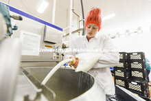 Molly Rosenthal pours ice cream base mix into a large mixing vat. The vat holds 50 gallons of mix. D