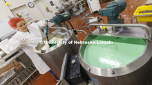 Assistant Dairy Plant Manager Mary Underwood pours in the coloring and flavor for the 100 gallons of