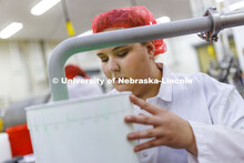 Assistant Dairy Plant Manager Mary Underwood swirls a 3-gallon bucket filling with 4-H Clover Mint b