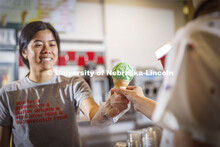 Vi Tran, a senior in actuary science, serves up a cone of Clover 4-H Mint. Ice cream is scooped up a