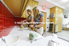 Brenna Mazour, a senior in psychology and dietetics, measures pasta as Meredith Brandt, junior in nu