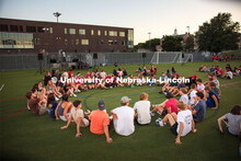 Students sit in a circle during the Playfair activity at the Vine Street Fields Wednesday night as p