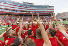 Drew Carlson, a freshman trumpet player from North Platte, is hoisted in the arms of the trumpet sec