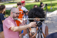 Walker Pickering talks about camera settings with Ella Gbetanou, a junior from Omaha, during PHOT 16