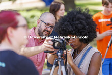 Walker Pickering talks about camera settings with Ella Gbetanou, a junior from Omaha, during PHOT 16