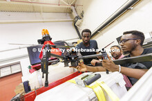 Herve Mwunguzi, Santosh Pitla and Terence Irumva discuss how a drone will be fitted to a robotic tra