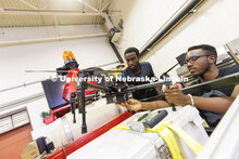 Herve Mwunguzi and Terence Irumva discuss how a drone will be fitted to a robotic tractor to refill 