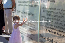 A young girl touches one of the glass panels of the new Veterans’ Tribute. Veteran's Memorial Cere