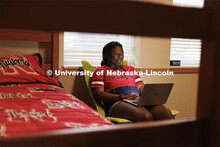 A student uses her laptop to study in her University Suites Residence Hall room. Housing Photo Shoot