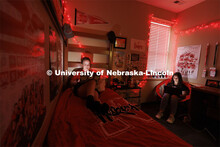Students studying by the glow of red christmas lights in a University Suites Residence Hall room. Ho