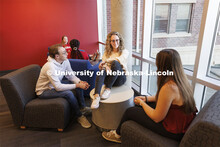 Students socializing in a commons area in University Suites Residence Hall. Housing Photo Shoot in U