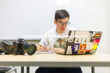 One student studying in a commons area in University Suites Residence Hall. Housing Photo Shoot in U