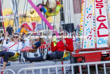 UNL Chancellor Ronnie Green and Husker Jane, his wife, take a spin on the Musical Chairs amusement r
