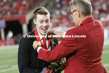 Newly crowned homecoming royalty Jacob Drake has a medallion placed over his head by Chancellor Ronn