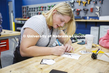 A Bay High student cuts out a vinyl sticker using an X-Acto knife. Bay Highschool students tour Inno