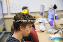 Student with a rubber duckie on his head. Students working in a classroom. Raikes School photo shoot