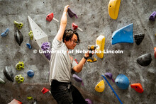 Phung Hong, senior student worker, securing a hold during the League of Extraordinary Boulderers. Le
