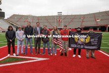Nebraska Athletic Director Trev Alberts hands over the game ball that will be part of the Ruck March