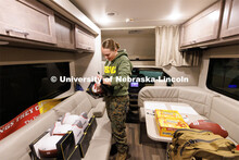 Jenalee Wimer, a junior in animal science and Marine Corp Reservist, signs donated footballs that ar