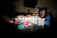 Domonique Cudjo, Assistant Director, Women's Center, sorts Holiday for Little Huskers gifts in the c