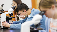 Nanqing Bian, a junior in Food Science and Technology, adjusts his microscope to view a mold sample.