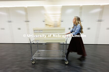 Sarah Walcott, collections manager, rolls a cart of quilts through the storage area. Quilts that can